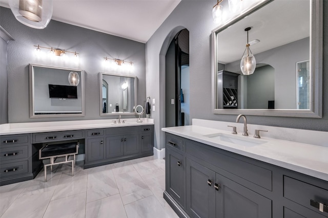 full bathroom with two vanities, a sink, and marble finish floor