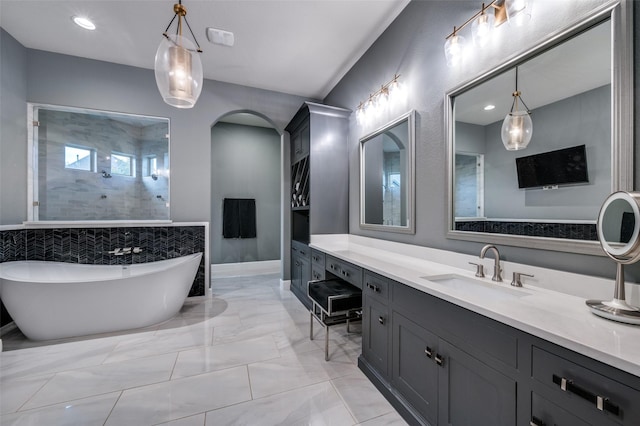 bathroom featuring walk in shower, vanity, marble finish floor, recessed lighting, and a freestanding tub