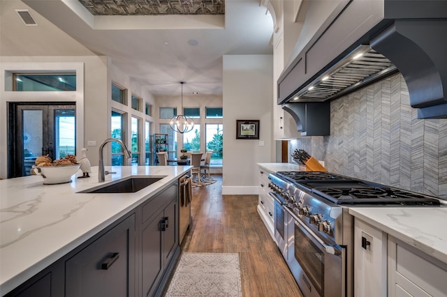 kitchen with visible vents, dark wood finished floors, a sink, custom exhaust hood, and stainless steel appliances
