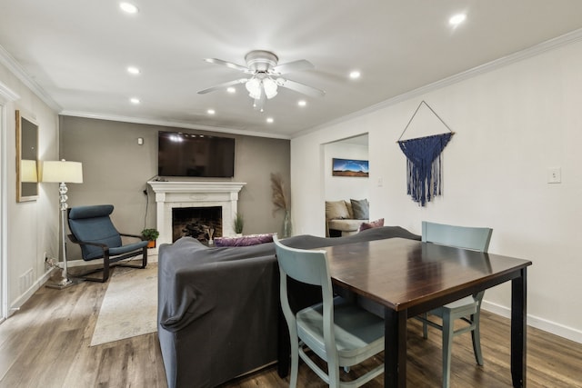 dining area featuring ceiling fan, a fireplace, recessed lighting, and wood finished floors