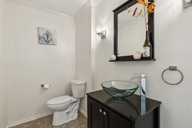 bathroom with baseboards, ornamental molding, vanity, and toilet