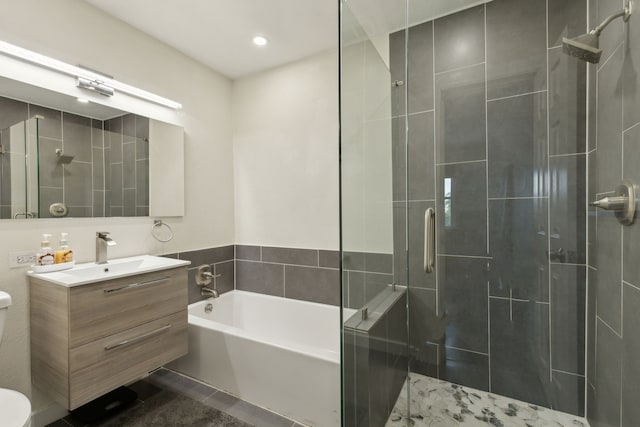 bathroom with vanity, toilet, recessed lighting, a shower stall, and a garden tub