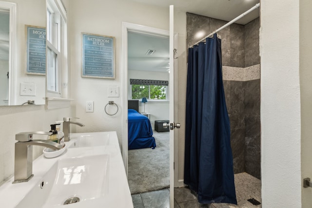 bathroom featuring a sink, tiled shower, visible vents, and ensuite bath