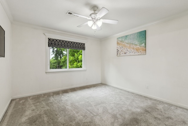 carpeted empty room with crown molding, baseboards, and a ceiling fan