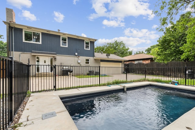 rear view of property featuring brick siding, a chimney, and a fenced backyard