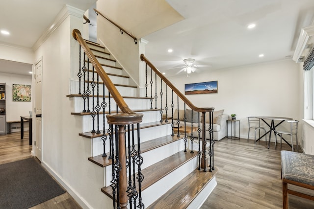 stairs with ornamental molding, a ceiling fan, recessed lighting, and wood finished floors