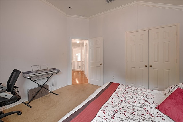 carpeted bedroom with visible vents, ornamental molding, lofted ceiling, and a closet