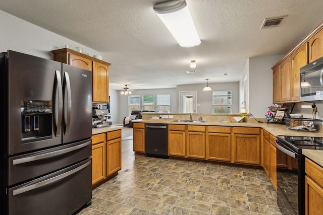 2041 Lake Trail Dr, Heartland, TX 75126 - kitchen featuring a peninsula, light countertops, brown cabinets, a sink, and stainless steel appliances