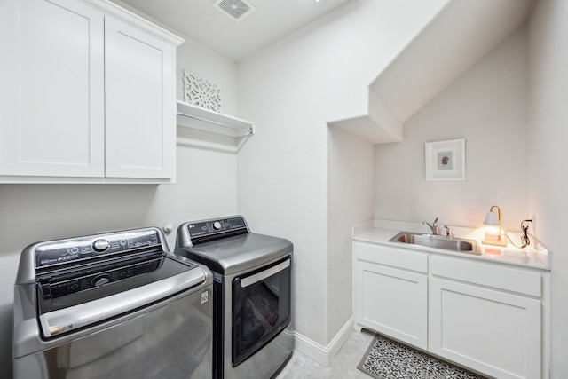 clothes washing area featuring visible vents, washing machine and dryer, baseboards, a sink, and cabinet space