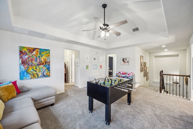 playroom featuring visible vents, carpet flooring, a raised ceiling, and a ceiling fan