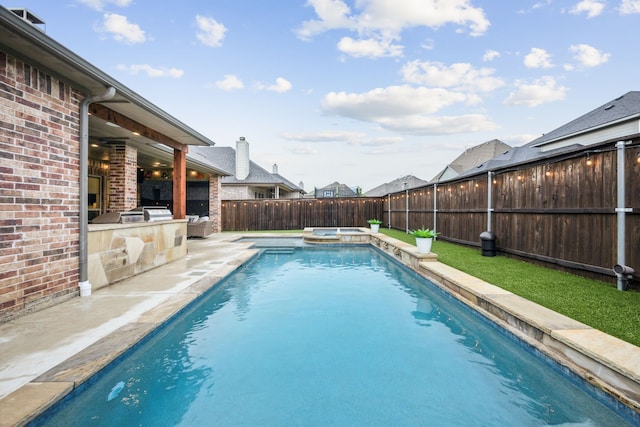 view of swimming pool featuring a fenced backyard, a patio, a pool with connected hot tub, and area for grilling