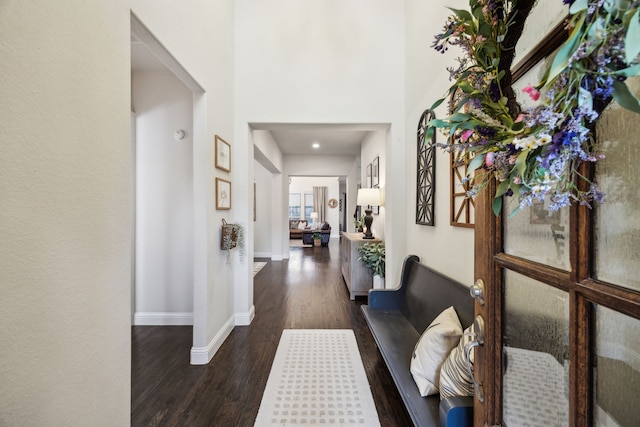 corridor featuring baseboards and wood finished floors