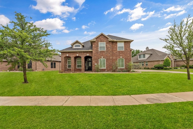 traditional-style house with brick siding and a front lawn