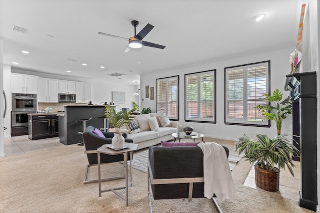 living room featuring a wealth of natural light, ceiling fan, and visible vents