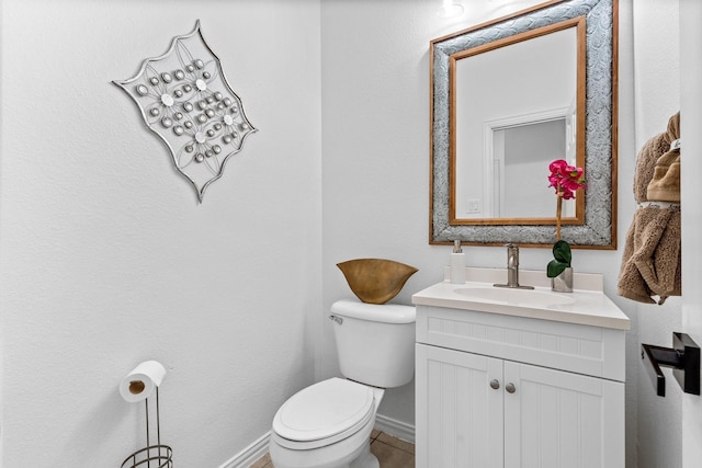 bathroom with toilet, baseboards, and vanity
