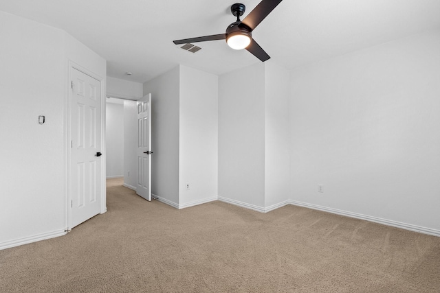 unfurnished bedroom featuring baseboards, light carpet, a ceiling fan, and visible vents