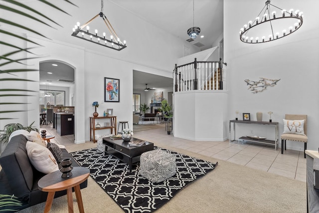living area with arched walkways, tile patterned flooring, a high ceiling, and a notable chandelier