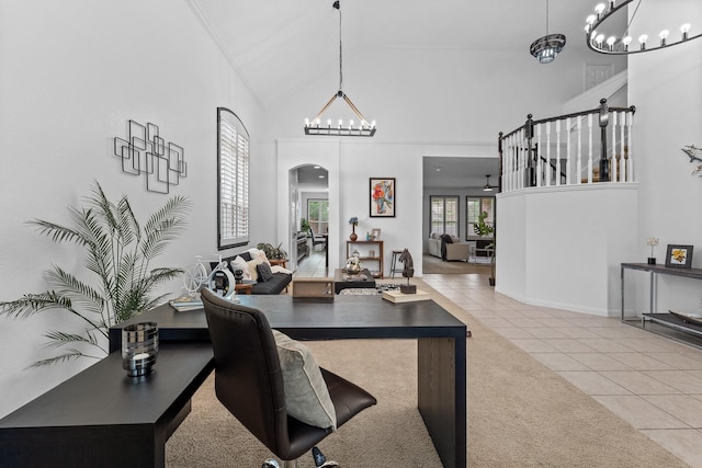 carpeted home office with arched walkways, tile patterned floors, a chandelier, and high vaulted ceiling