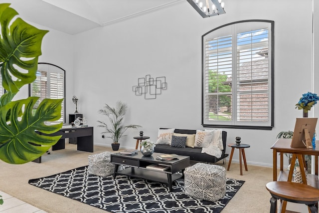 living area featuring carpet floors, baseboards, vaulted ceiling, and an inviting chandelier