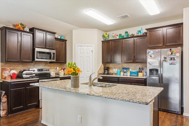 kitchen featuring a sink, appliances with stainless steel finishes, dark brown cabinetry, and dark wood-style floors