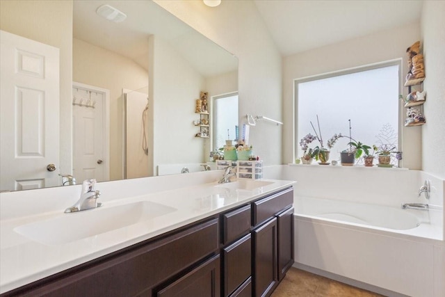 bathroom with double vanity, a sink, and a bath