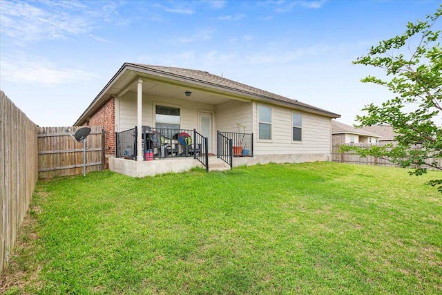 rear view of property featuring a fenced backyard and a yard