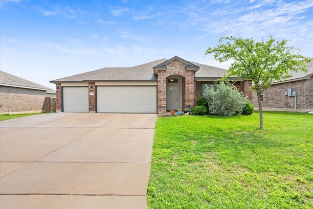 view of front of house with a shingled roof, an attached garage, a front lawn, brick siding, and concrete driveway