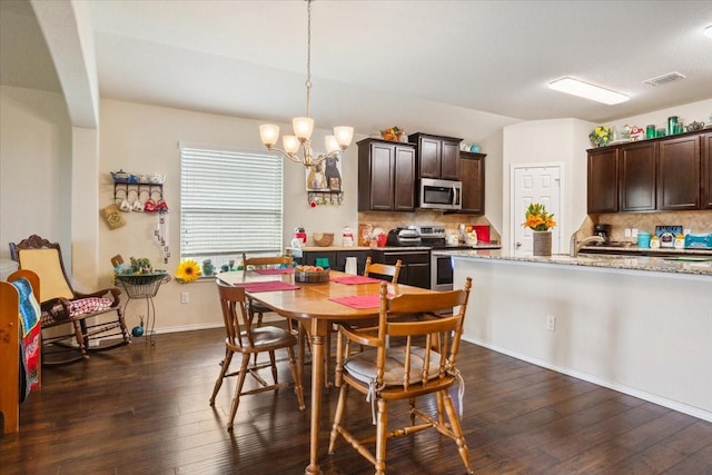 dining space with a chandelier, baseboards, visible vents, and dark wood-style floors