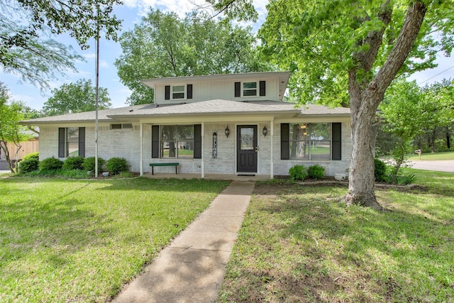 traditional-style house with covered porch, brick siding, and a front yard
