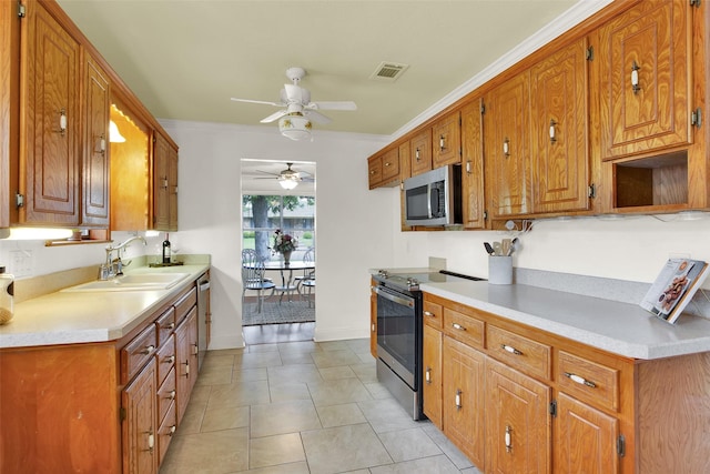 kitchen with visible vents, a ceiling fan, brown cabinets, a sink, and stainless steel appliances