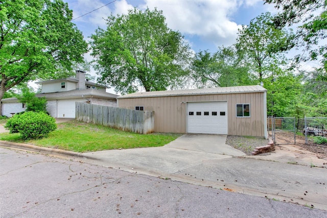 garage featuring fence and driveway