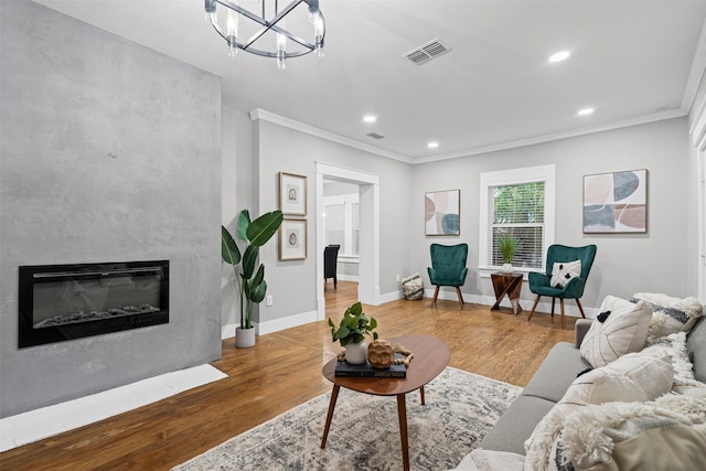 living room featuring visible vents, ornamental molding, wood finished floors, and a notable chandelier