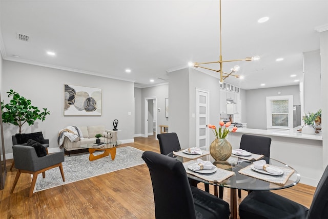 dining room featuring visible vents, a chandelier, light wood-style floors, ornamental molding, and recessed lighting