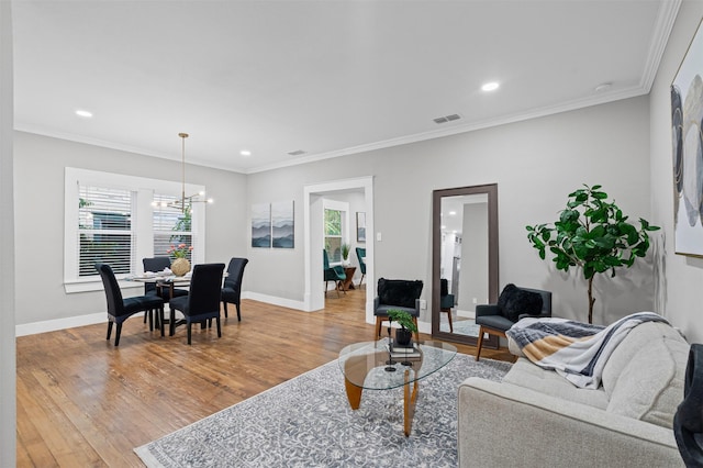 living area with baseboards, visible vents, an inviting chandelier, and light wood-type flooring