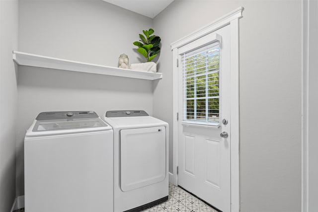 clothes washing area with laundry area, light floors, and washing machine and dryer