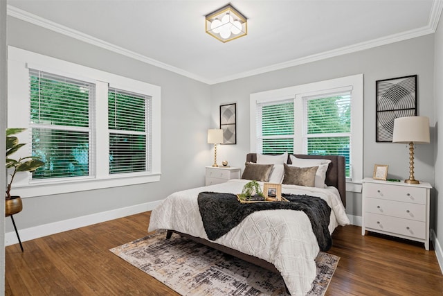 bedroom with crown molding, baseboards, and wood finished floors