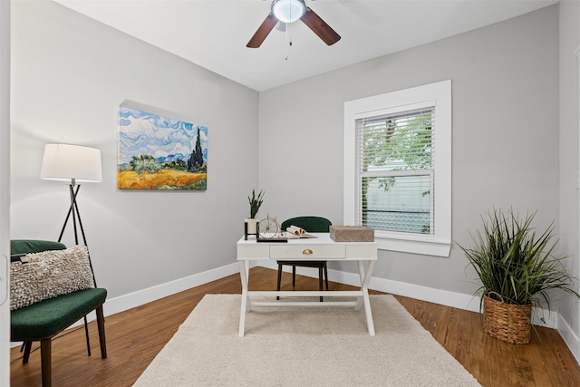 home office with a ceiling fan, baseboards, and wood finished floors