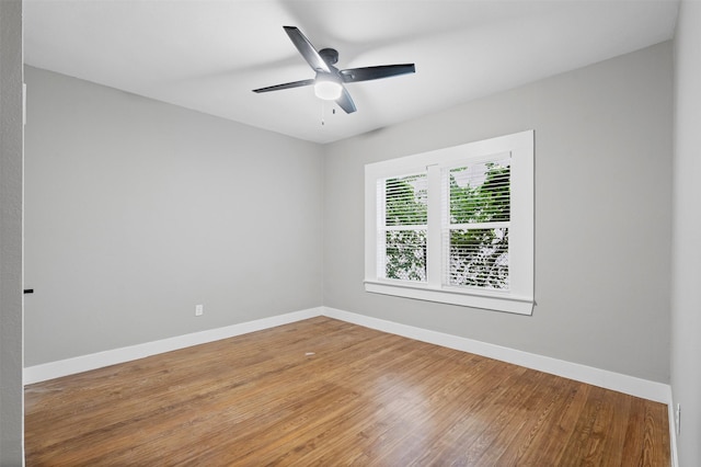 unfurnished room with baseboards, a ceiling fan, and wood finished floors