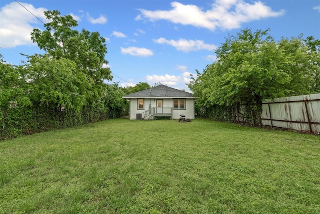 view of yard featuring central AC and fence