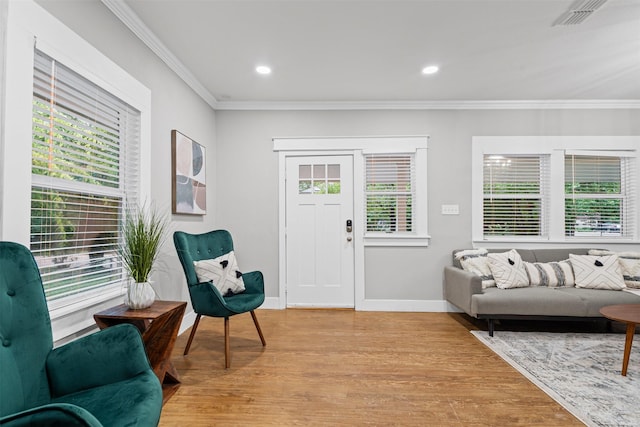interior space featuring crown molding, plenty of natural light, light wood finished floors, and visible vents