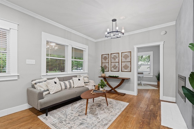 living area featuring ornamental molding, wood finished floors, and a chandelier