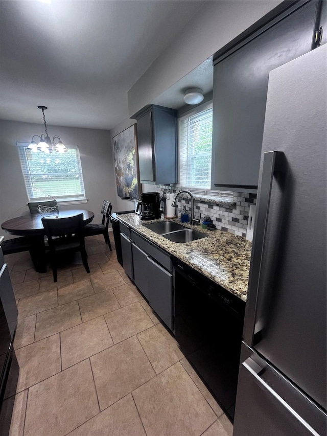 2551 Mossglen Dr, Dallas, TX 75227 - kitchen featuring freestanding refrigerator, a sink, backsplash, a chandelier, and light tile patterned floors
