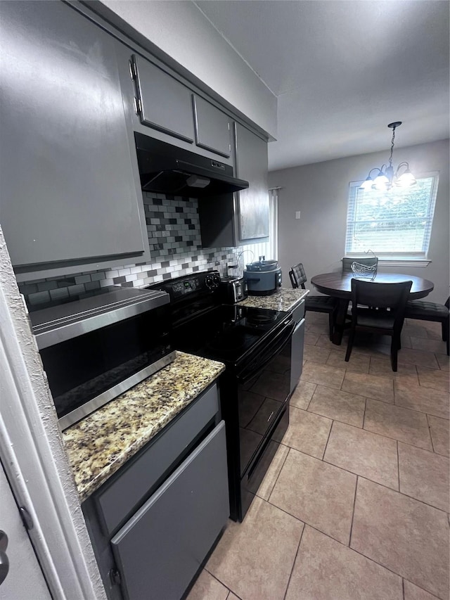 2551 Mossglen Dr, Dallas, TX 75227 - kitchen with black / electric stove, stainless steel microwave, under cabinet range hood, backsplash, and a chandelier