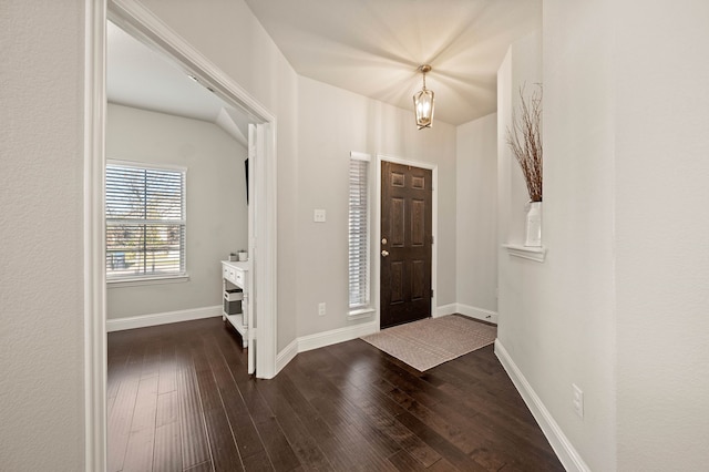 foyer entrance featuring baseboards and dark wood-type flooring