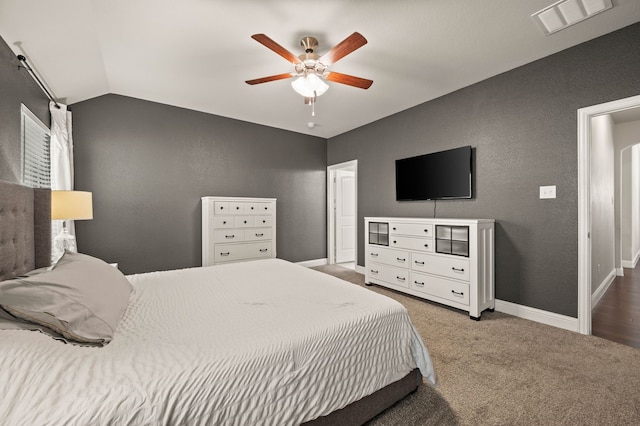 bedroom with a textured wall, carpet flooring, visible vents, and lofted ceiling