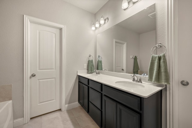 full bathroom with double vanity, a sink, tile patterned floors, and a tub to relax in