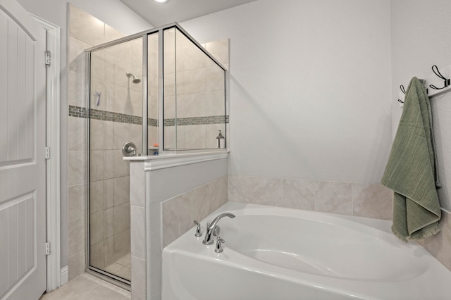 bathroom featuring a garden tub, tile patterned floors, and a shower stall