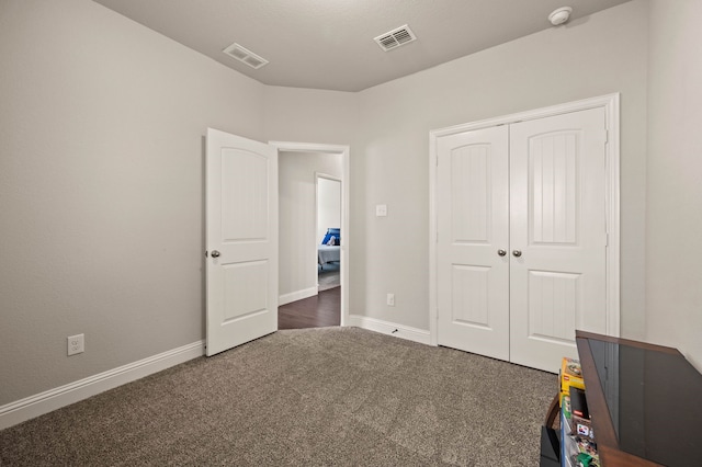 unfurnished bedroom featuring visible vents, baseboards, carpet floors, and a closet