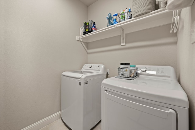 clothes washing area featuring baseboards, laundry area, and washer and dryer