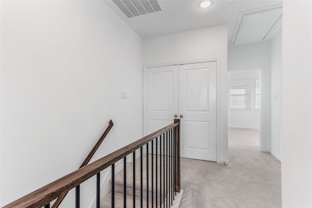 hallway with visible vents, attic access, light colored carpet, recessed lighting, and an upstairs landing